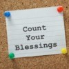 A note card on a bulletin board that says count your blessing on it.