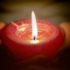 A person holding a red candle.
