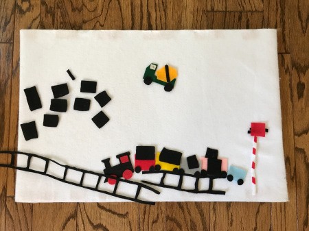 Felt Story Board - board with felt pieces, including cement truck, train cars, cargo, and track