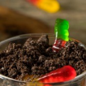 Gummy worms crawling out of a small dirt cake.