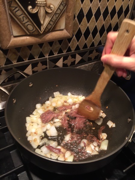 adding anchovies to onion and garlic