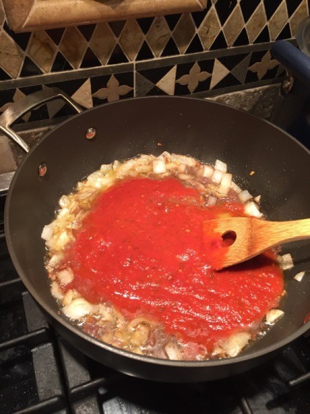 adding spaghetti sauce to pan