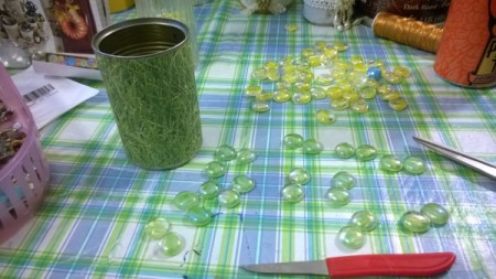 Tin Can Organizers - grass paper on can and green glass nuggets on workspace
