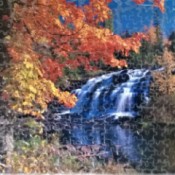 A finished puzzle of a waterfall in autumn.