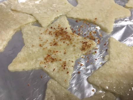 sprinkling Tortilla Chips with taco seasoning