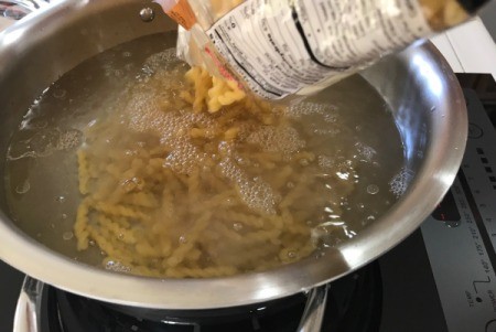adding pasta to boiling water