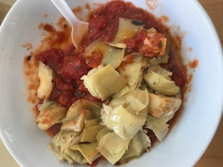 mixing pasta sauce and artichoke halves