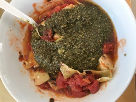 adding pesto to artichoke halves and pasta sauce