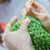 A crochet craft being made with green yarn.