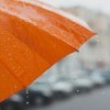 An orange umbrella in the rain.