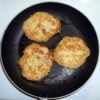 Main Ingredient in Potato Pancakes - pan with three potato pancakes cooking