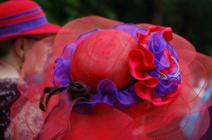 Women wearing fancy red hats.