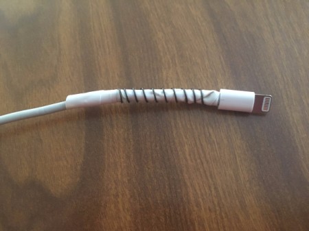 A repaired electronic charging cord, with a spring.