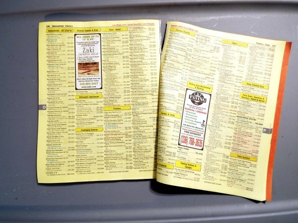 Pages from a phone book to be made into seedling pots.