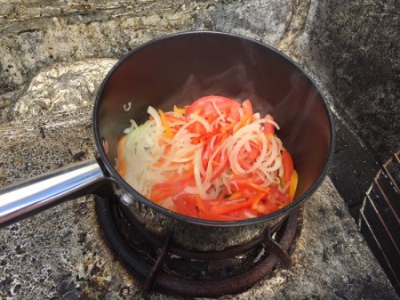 onion, peppers and tomatoes in pan