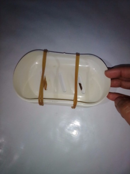 Two rubber bands to hold a bar of soap over a soap dish.