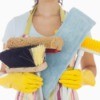 A professional cleaner holding cleaning supplies.