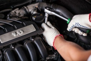 A mechanic's hands working on a car engine.