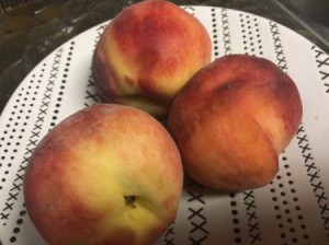 Three ripe peaches, ready for peeling.