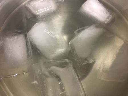 Placing a peach in ice water to remove the skin.