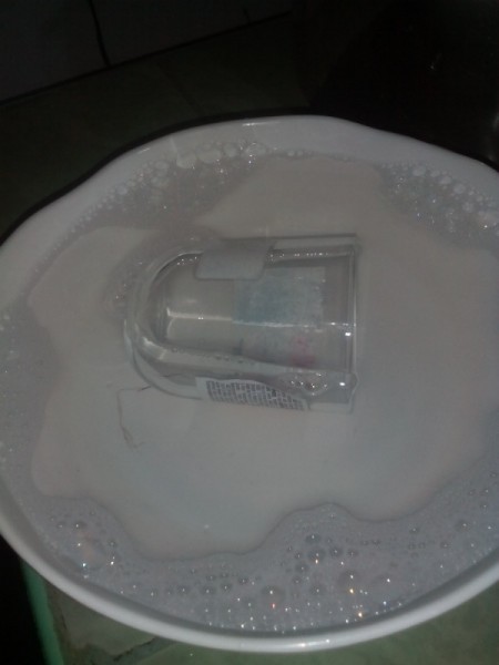 A recycled jar soaking in a soap solution.