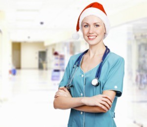 A female healthcare worker wearing a santa hat.