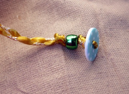 Button and Bead Knotted Bracelet - thread first bead on both cords and tie a knot