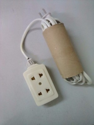 An extension cord tucked into a recycled tissue roll.