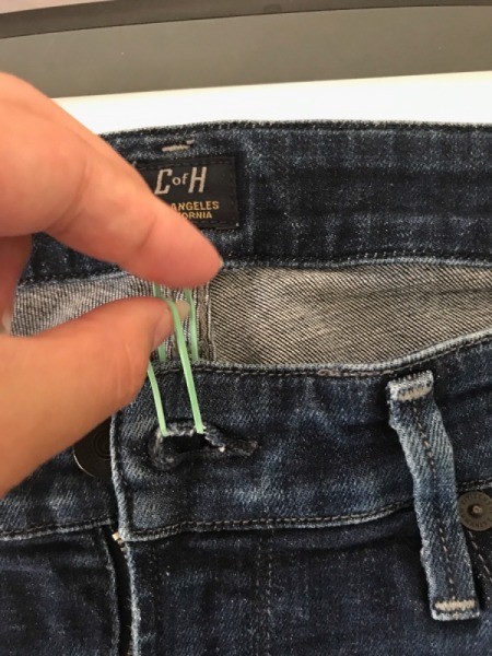 A rubber band to hold a pair of jeans closed.