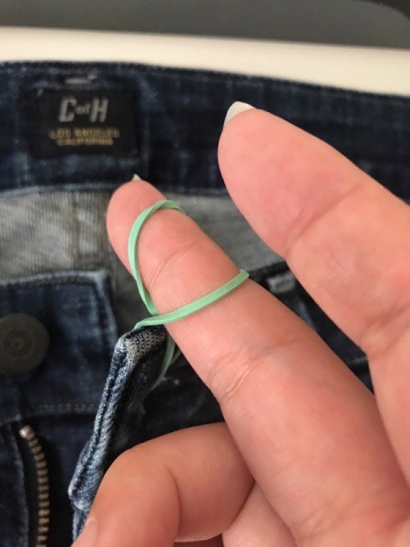 A rubber band to hold a pair of jeans closed.