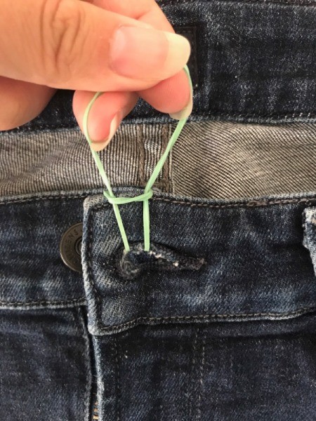 A rubber band to hold a pair of jeans closed.