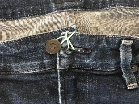 A rubber band to hold a pair of jeans closed.