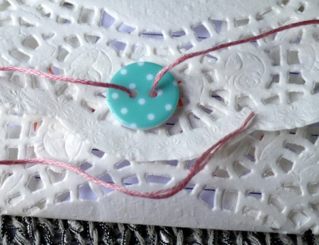 Paper Doily Envelope - thread floss ends through button