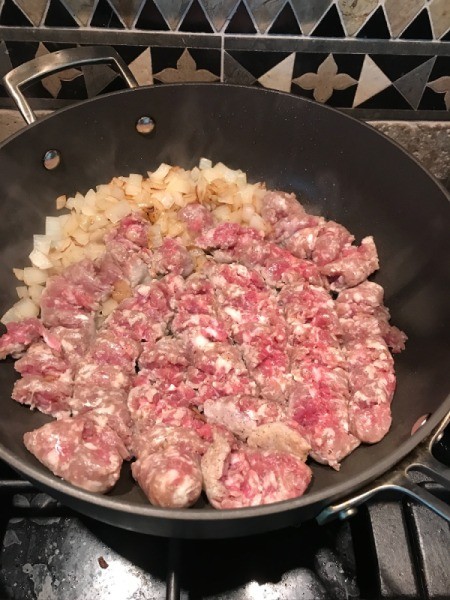 onion and sausage in pan