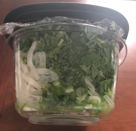 Saran wrap on top of a reusable food container before the lid is placed.