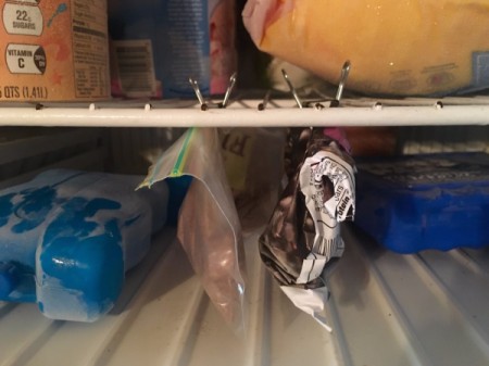Clipping small bags to the freezer shelf using binder clips.