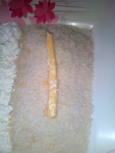 dipping cheese stick in bread crumbs