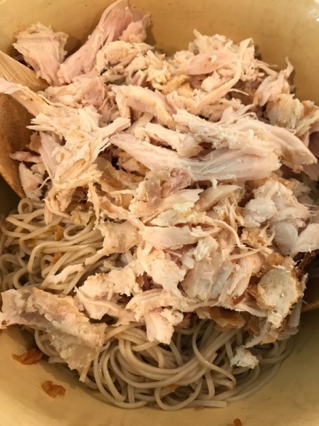 adding chicken to noodles