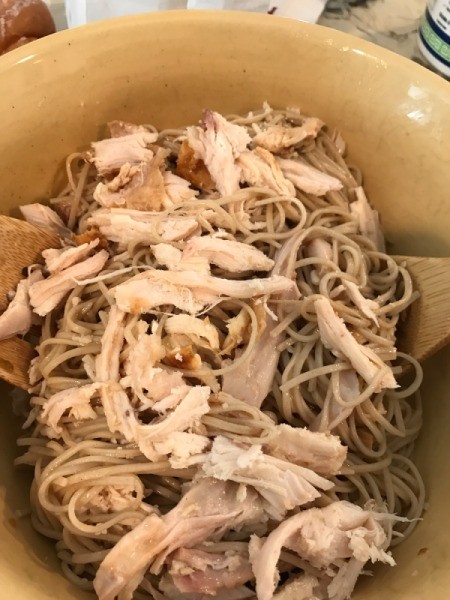 mixing chicken with noodles