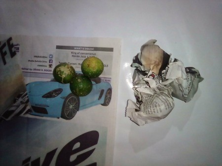 A handful of citrus fruit wrapped in newspaper for storage.