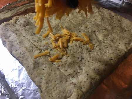 sprinkling shredded cheese on mixture