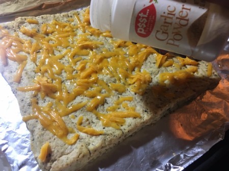 sprinkling garlic powder on mixture