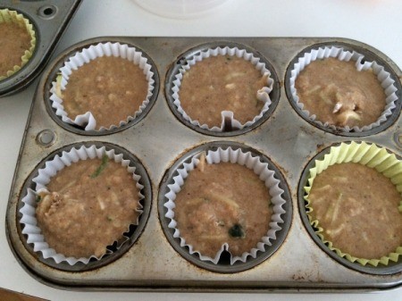pouring batter in lined muffin tins
