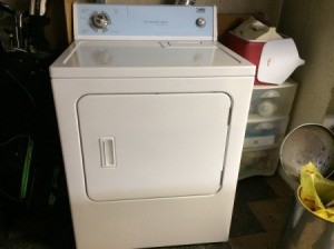 A white clothes dryer in a laundry room.