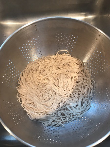 cooked soba noodles in colander