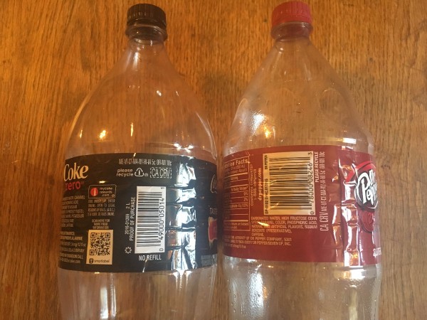 Two empty 2-liter bottles of soda pop.