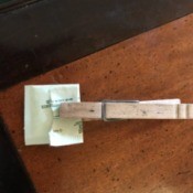 A clothespin holding a single serving packet of sweetener closed.