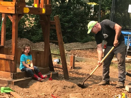 Refinishing a Wooden Playground - man digging