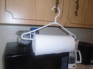 A roll of paper towels on a plastic clothes hanger.