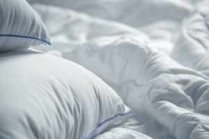 A white bed spread with white pillows